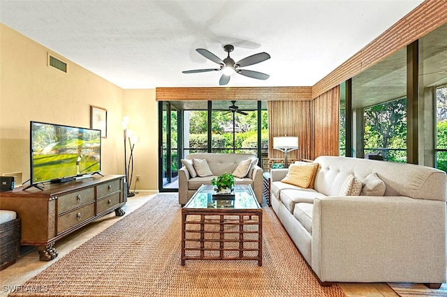 living area featuring a ceiling fan and visible vents