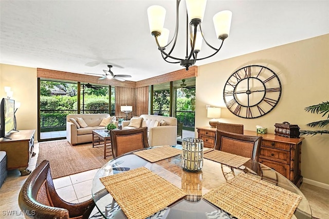 dining room with ceiling fan with notable chandelier, wooden walls, and light tile patterned floors