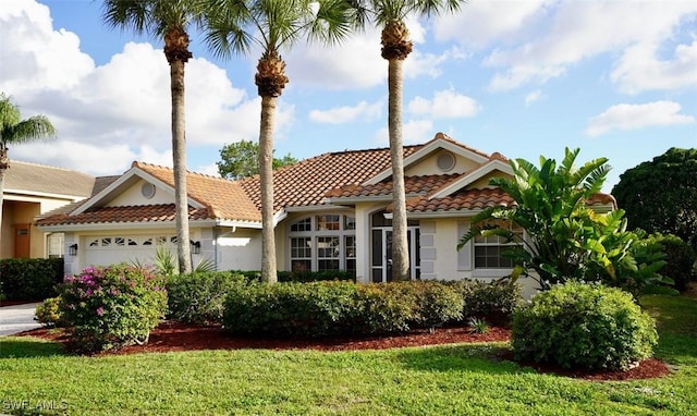 mediterranean / spanish-style home with a front yard and a garage