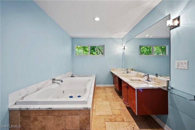 bathroom featuring vanity, tiled bath, and a wealth of natural light