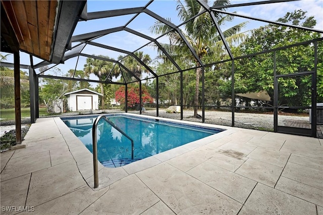 view of pool with a patio area, glass enclosure, and a storage unit