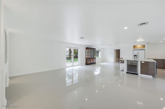 unfurnished living room with french doors and beverage cooler