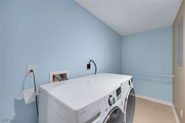 clothes washing area with separate washer and dryer and light wood-type flooring