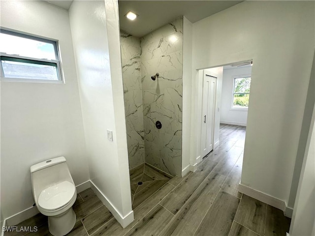 bathroom with tiled shower and toilet