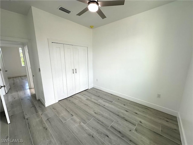 unfurnished bedroom featuring ceiling fan and a closet