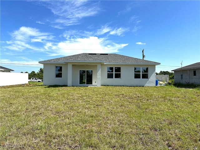 rear view of house featuring a lawn