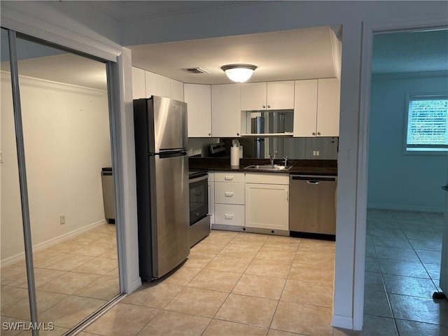 kitchen with sink, light tile patterned floors, crown molding, white cabinetry, and stainless steel appliances