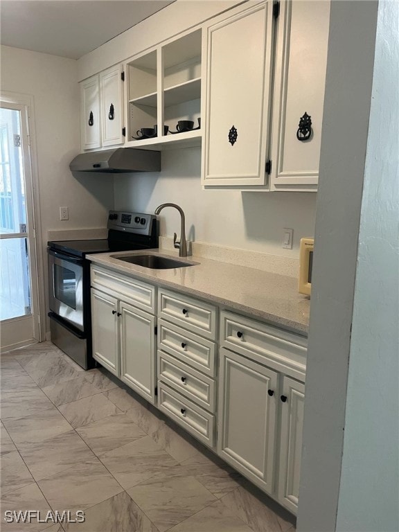 kitchen featuring stainless steel range with electric stovetop, white cabinetry, and sink