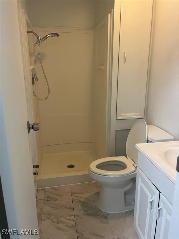 bathroom with a shower, vanity, and toilet