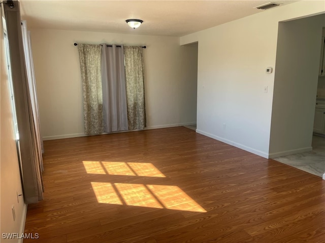 unfurnished room with hardwood / wood-style floors