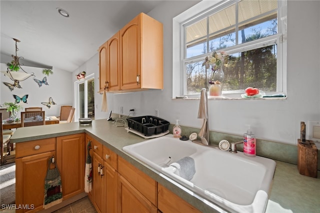 kitchen featuring lofted ceiling, kitchen peninsula, plenty of natural light, and pendant lighting