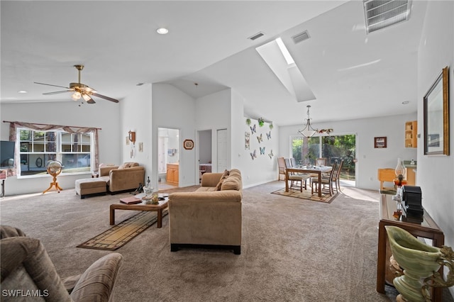 carpeted living room with ceiling fan and lofted ceiling with skylight