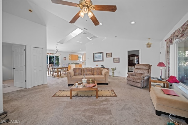 carpeted living room with ceiling fan and vaulted ceiling