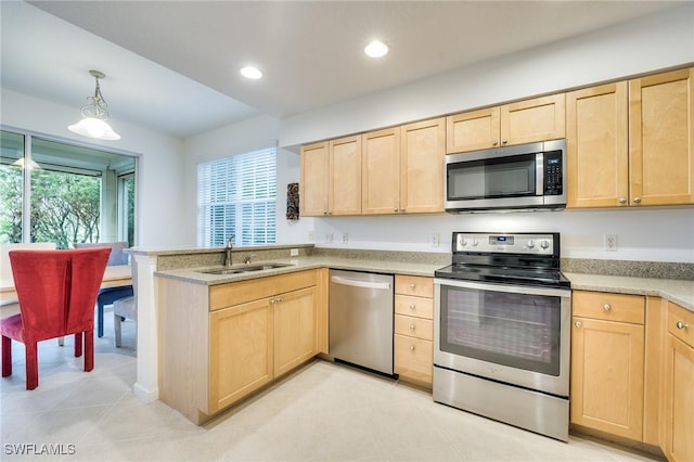 kitchen with stainless steel appliances, sink, light brown cabinets, and decorative light fixtures