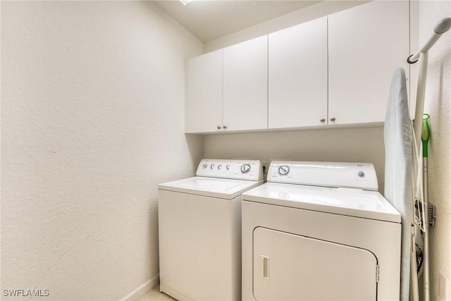 laundry room with cabinets and washer and clothes dryer