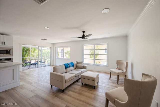 living room featuring ceiling fan, light hardwood / wood-style floors, and ornamental molding