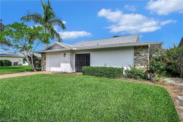 ranch-style house featuring a front lawn and a garage