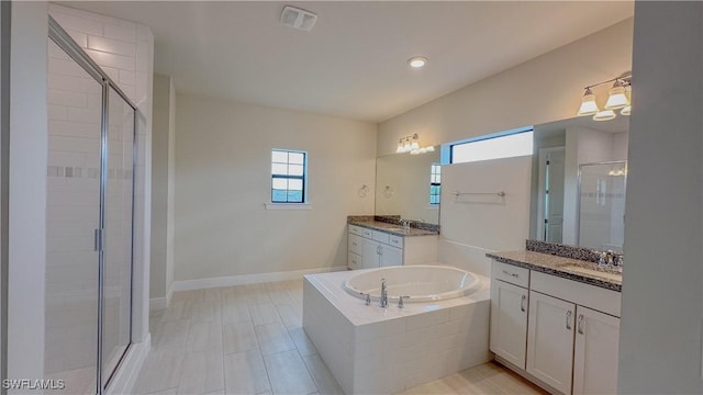 bathroom with vanity, tile patterned flooring, and plus walk in shower