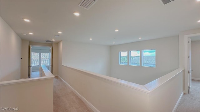 hallway featuring light colored carpet