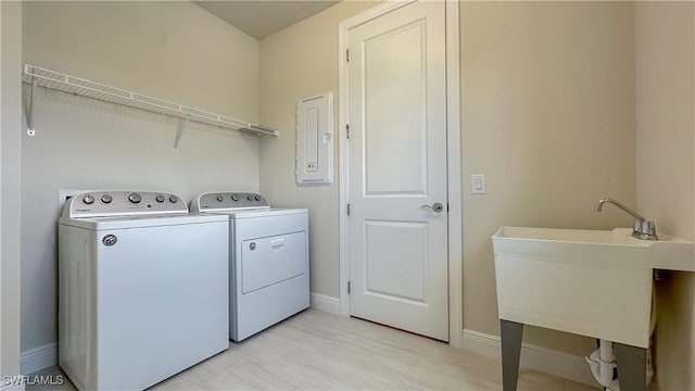 clothes washing area with electric panel and washing machine and dryer