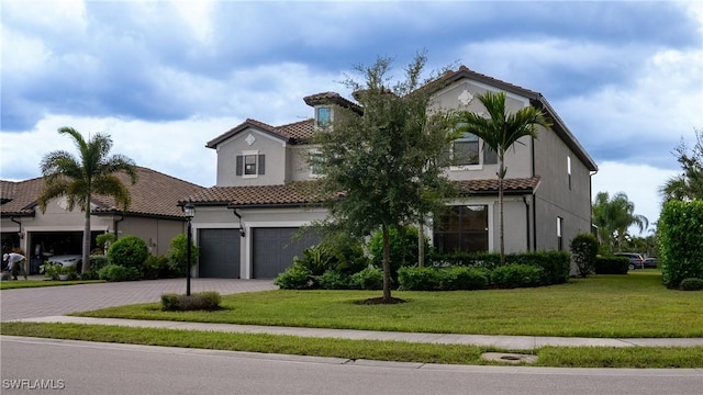 mediterranean / spanish house featuring a front yard and a garage