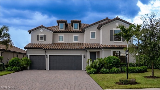 mediterranean / spanish-style house featuring a front lawn and a garage