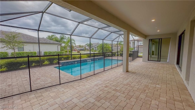 view of swimming pool with glass enclosure and a patio area