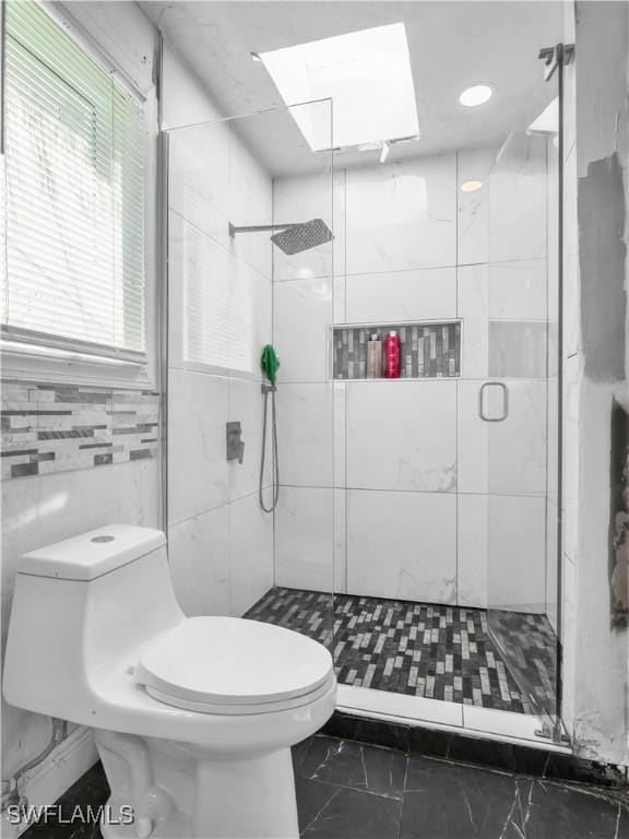 bathroom featuring toilet, an enclosed shower, and tile walls