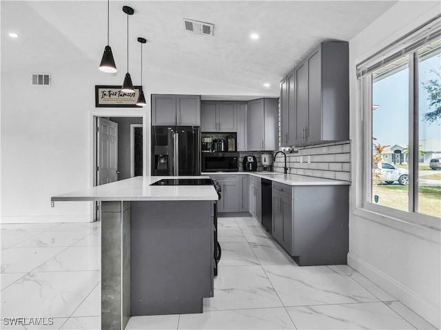 kitchen with pendant lighting, sink, gray cabinetry, a center island, and black appliances