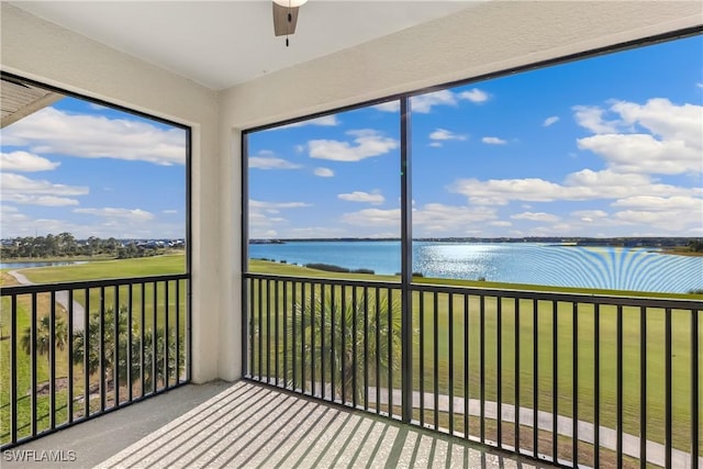 unfurnished sunroom featuring a water view and ceiling fan