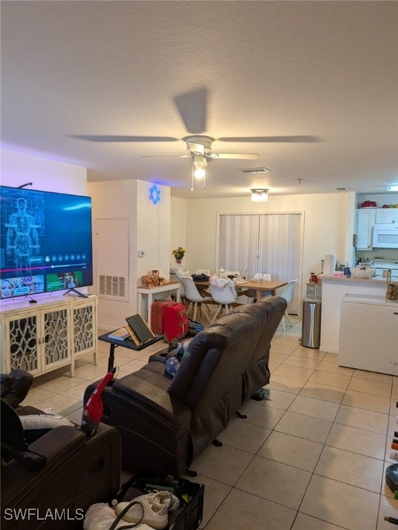 tiled living room featuring ceiling fan