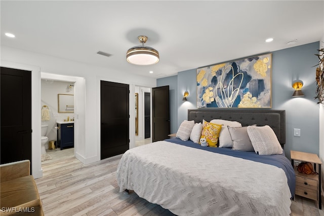 bedroom featuring recessed lighting, visible vents, light wood-style flooring, ensuite bathroom, and baseboards