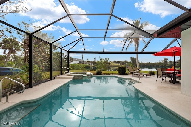 view of pool featuring glass enclosure, a patio area, a pool with connected hot tub, and a water view