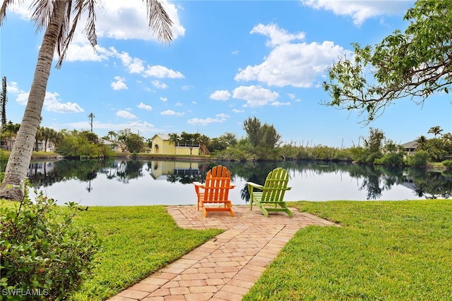 exterior space featuring a water view, a patio area, and a lawn