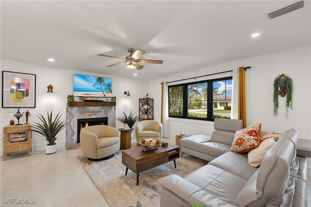 living area with recessed lighting, visible vents, a ceiling fan, a high end fireplace, and speckled floor