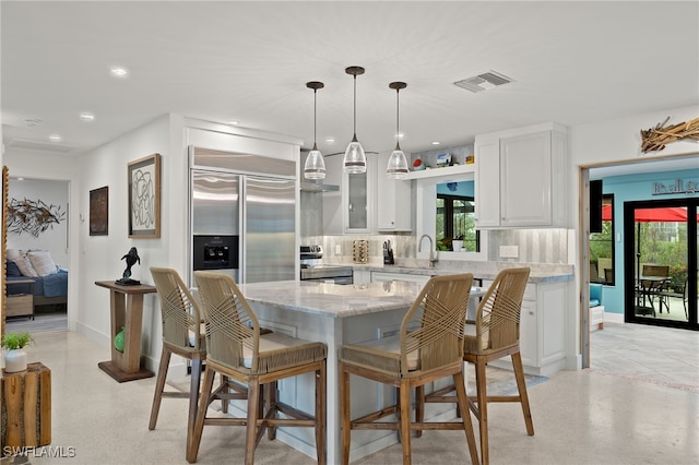 kitchen with visible vents, decorative backsplash, light stone counters, stainless steel appliances, and white cabinetry