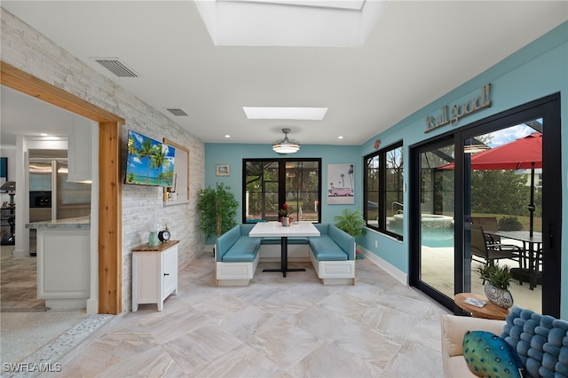 unfurnished sunroom featuring a skylight and visible vents