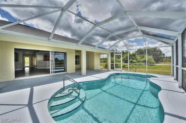 view of pool with glass enclosure and a patio