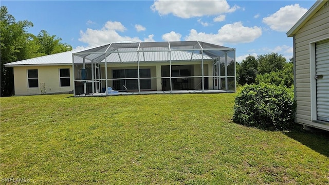 rear view of property featuring glass enclosure and a yard