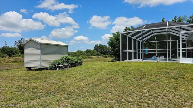 view of yard with a lanai, a pool, and a storage unit