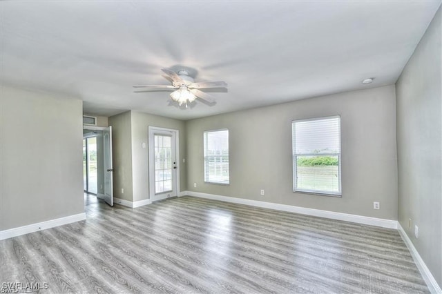 spare room with light hardwood / wood-style flooring, a wealth of natural light, and ceiling fan