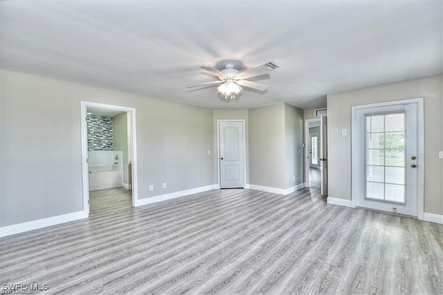 empty room with ceiling fan and light hardwood / wood-style flooring