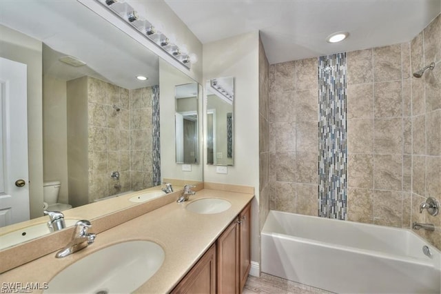 full bathroom with vanity, tiled shower / bath, and toilet