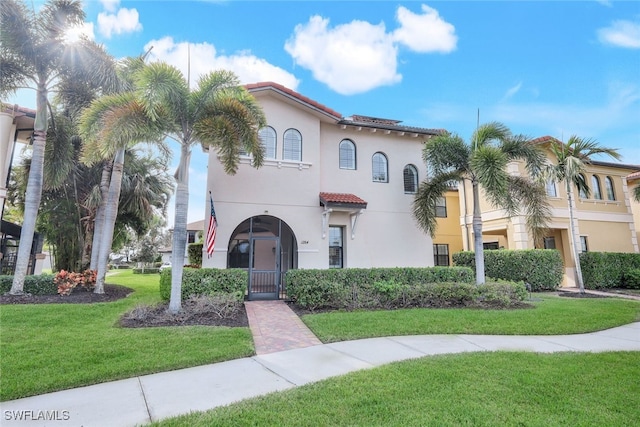 mediterranean / spanish home with a front lawn