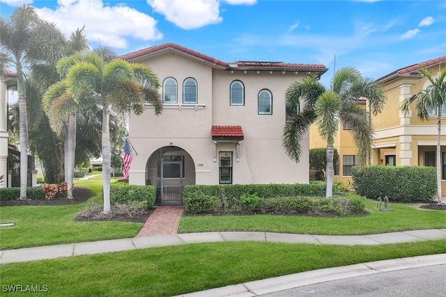 mediterranean / spanish home with a front lawn