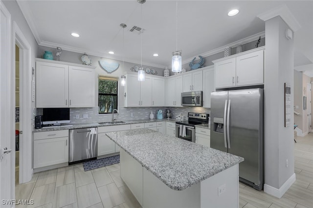 kitchen featuring stainless steel appliances, white cabinetry, a kitchen island, and sink