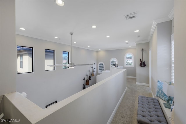 corridor with crown molding and light carpet