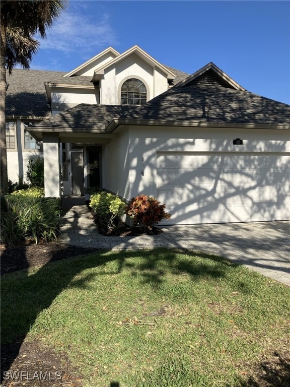 view of front of property with a garage and a front lawn