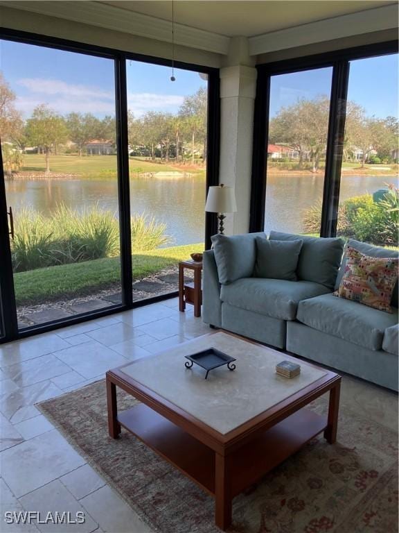 living room featuring plenty of natural light, a water view, and a wall of windows