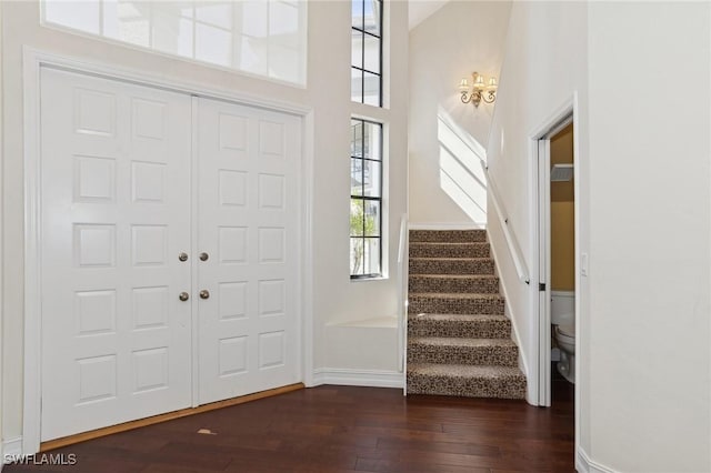 foyer featuring a towering ceiling and dark hardwood / wood-style flooring